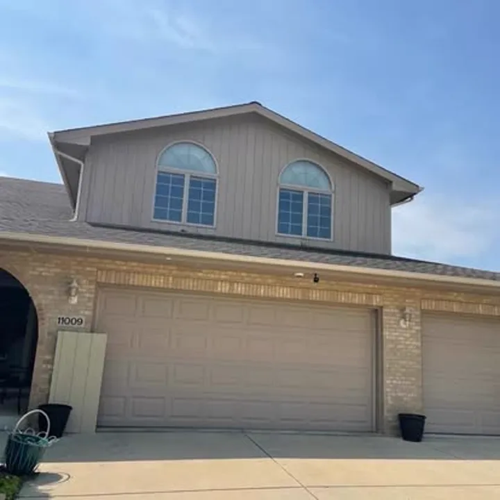 Brick two-flat with freshly painted blue-gray garage and trim